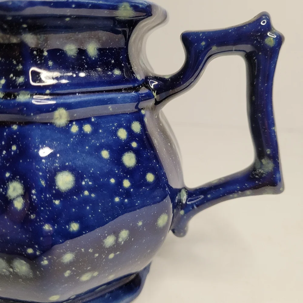 A blue and white speckled teapot. 271